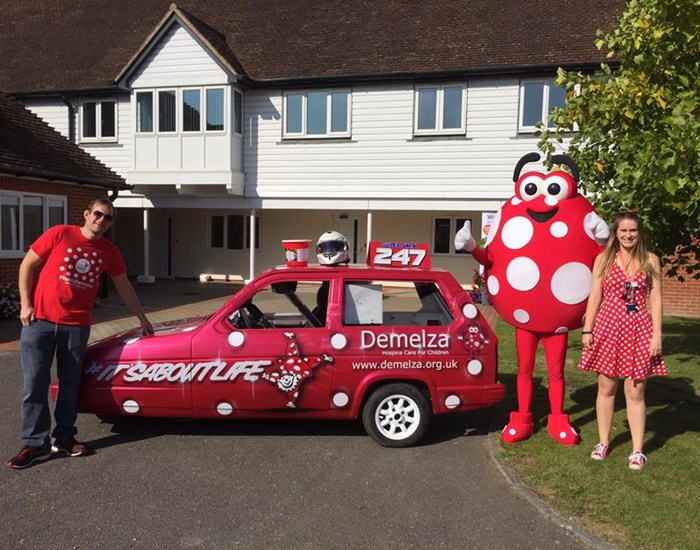 Demelza's Dotty, stands next to a dotty car, outside the Kent hospice.