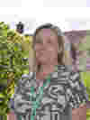 Katie Stevens, Director of Clinical Services, stands in Demelza’s gardens wearing a patterned top and smiling.