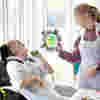 Image of child looking at lady holding artwork
