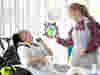 Image of child looking at lady holding artwork