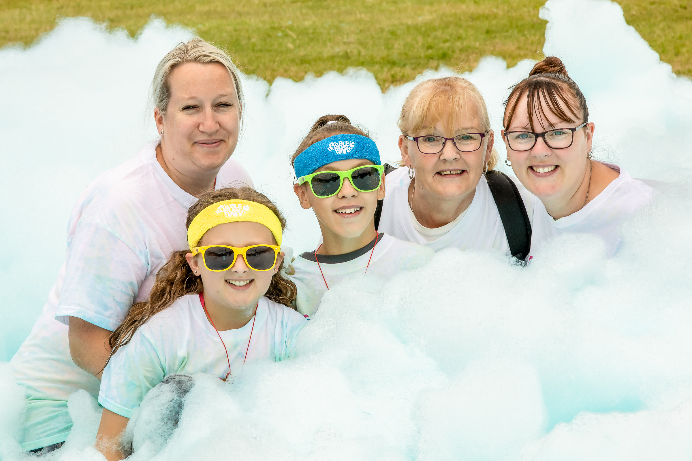 A group of Bubble Rush participants surrounded by foam bubbles.