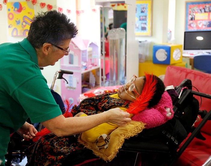 A girl enjoys a sensory activity with a Health Care Assistant at Demelza's Eltham hospice.