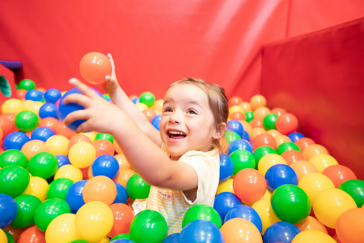 Ava-Lily throwing a ball in the ball pit at Demelza.