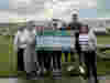 A group of people who work for Rye Bay Caravan Park holding up a cheque for £4027.73 for Demelza