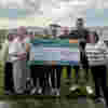A group of people who work for Rye Bay Caravan Park holding up a cheque for £4027.73 for Demelza