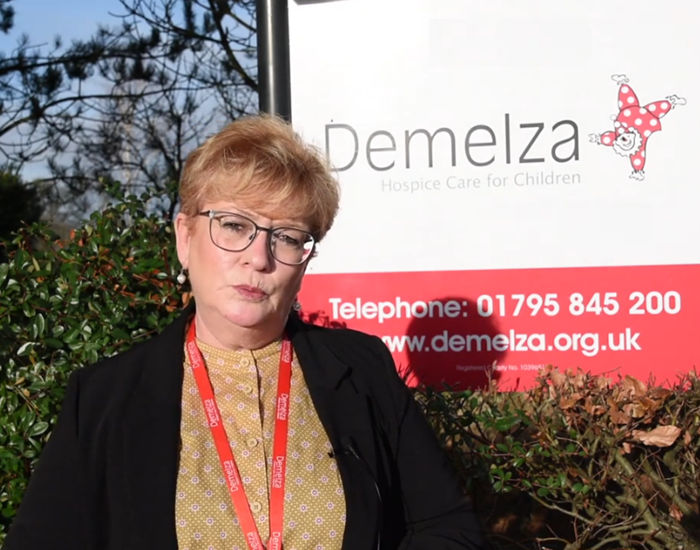 Demelza's Acting CEO, Lavinia Jarrett standing by the entrance of Demelza's Kent hospice.