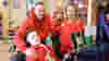 Mum, dad, sister and son in a wheelchair in a play room smiling to camera