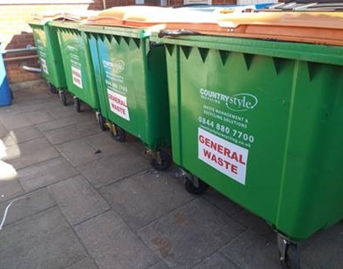 Large green recycling bins.