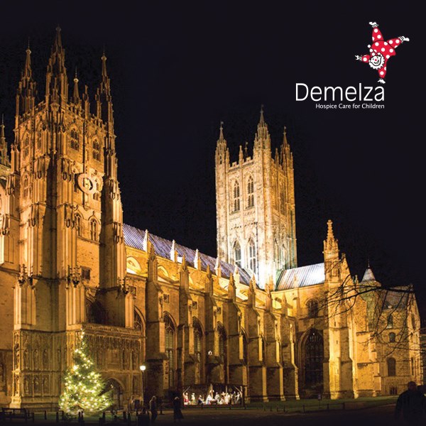 Canterbury Cathedral is light up with lights against a dark night sky.