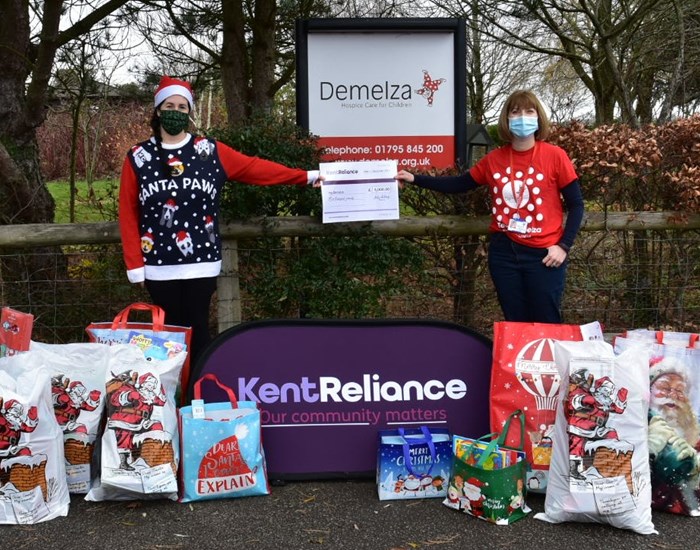 Kent Reliance delivering Christmas gifts to Demelza Kent, wearing Christmas jumpers.