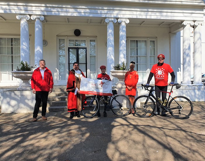 Fundraisers Matthew and Vernon Hill pose with their bikes and the Mayor of Broadstairs, holding a Demelza banner and wearing Demelza t-shirts.