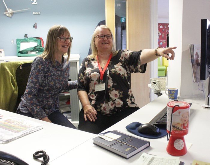 Two volunteers work together on reception at the Kent hospice.