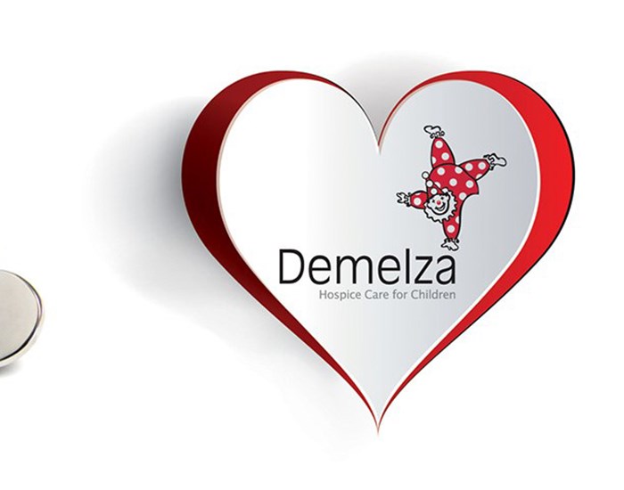 Four heart shaped pin badges  next to Demelza's logo, sat within a heart.