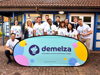 Corporate team with Demelza branded sign