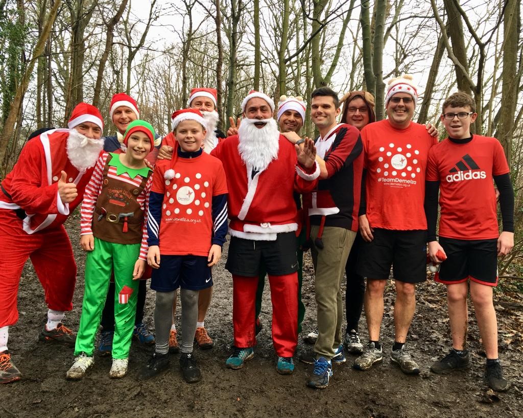 A team of fundraisers, wearing Demelza tops and Christmas hats during a Christmas fun run.
