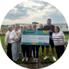 A group of people who work for Rye Bay Caravan Park holding up a cheque for £4027.73 for Demelza