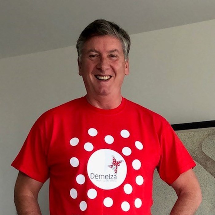 Robin Cousins wearing a Demelza supporter t-shirt, smiling.