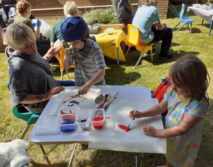 Children enjoying a painting activity in the garden.