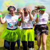 A group of Demelza participants running through powders of colours