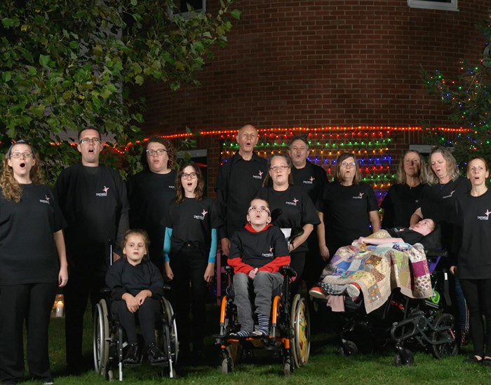 Demelza's Fall on Me Choir stands outside the Kent hospice, wearing matching black outfits.