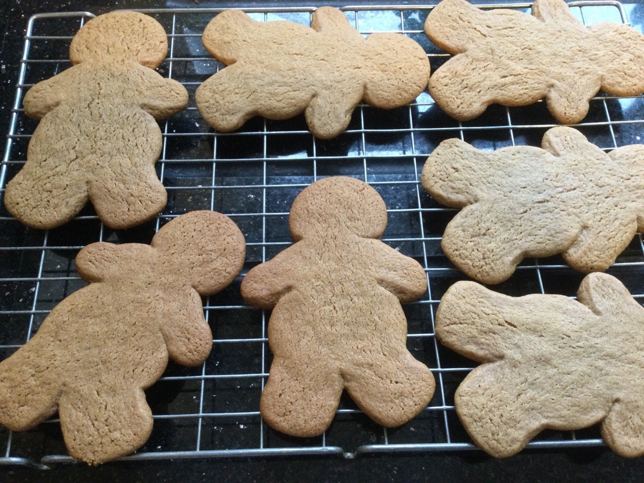 Baked gingerbread men, on a cooling tray.