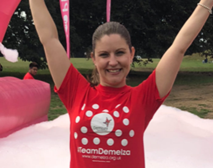 Karen is volunteering at Demelza's Bubble Rush event, surrounded by pink bubbles.