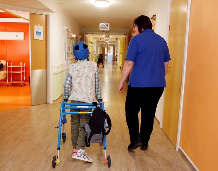 Jack and a Registered Nurse walking down the care corridor at Demelza Kent.