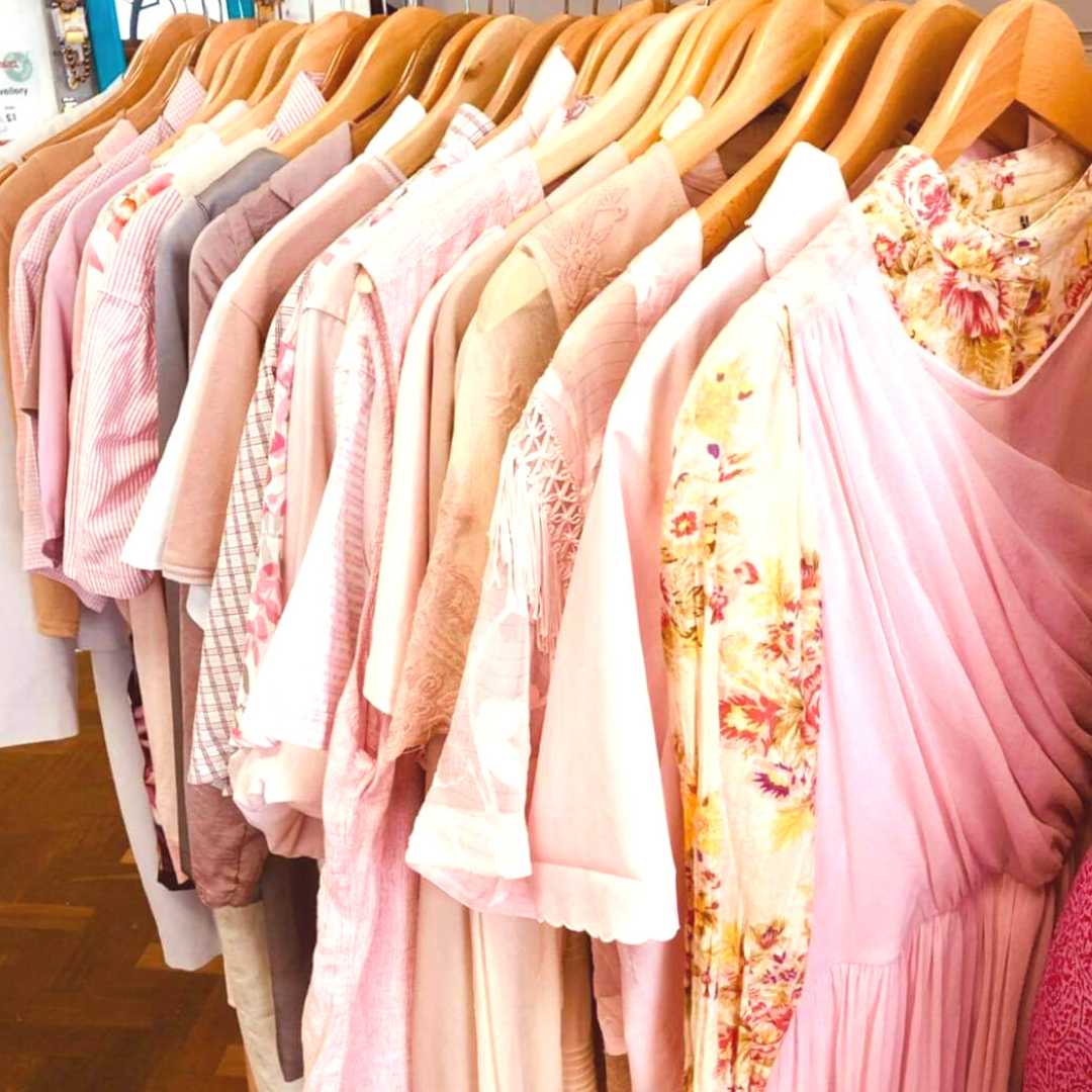 A clothing rail with all pink clothing.
