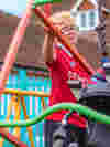 Young person standing by the Demelza swing in the park