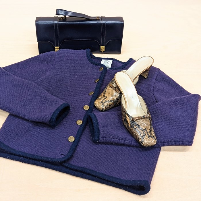 Vintage handbag, cardigan and shoes laid out 