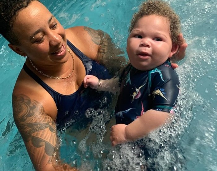 Kai is in the hydro pool, laying in his mum's arms.