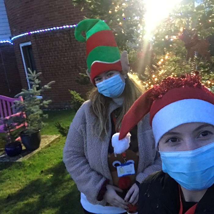 Two women wearing Christmas hats and medical facemasks at Demelza's Kent hospice.