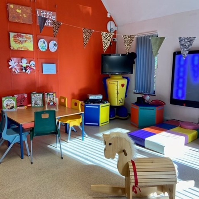 A room filled with toys, including a small wooden horse.
