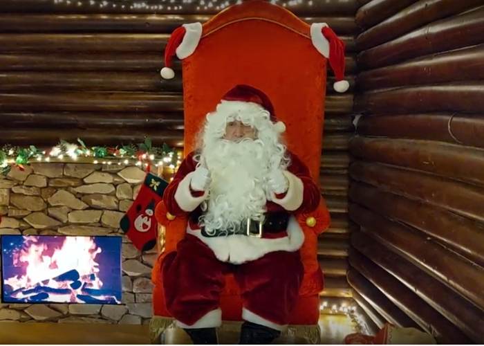 Volunteer, Keith, is dressed as Father Christmas and he is sitting in his grotto.