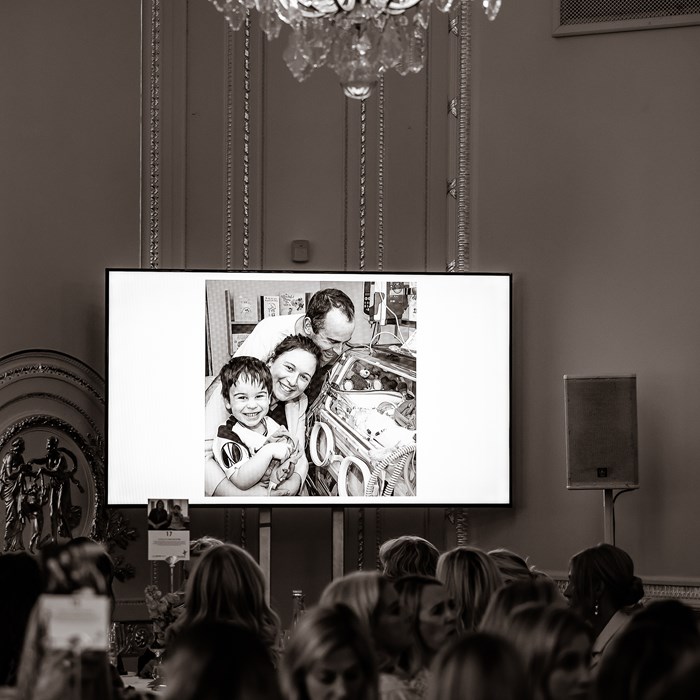 A photo of a family, on a large screen at the autumn lunch.