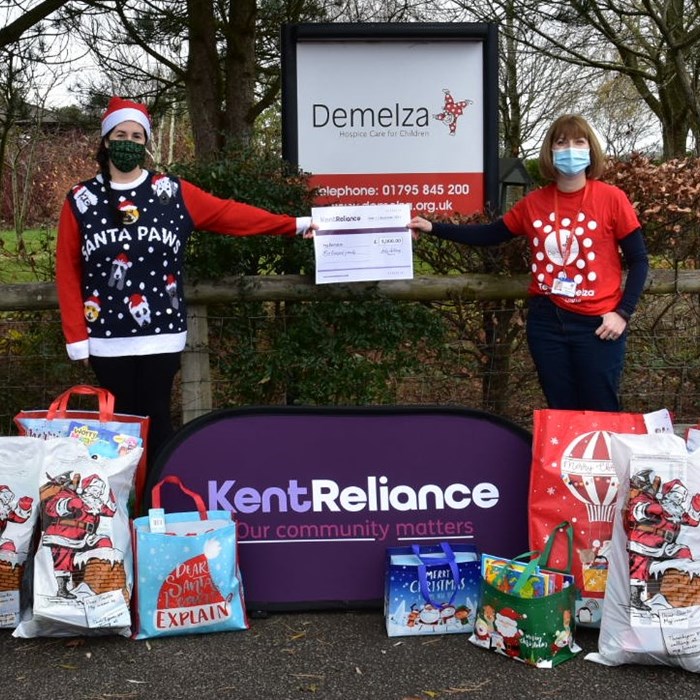 Kent Reliance delivering Christmas gifts to Demelza Kent, wearing Christmas jumpers.