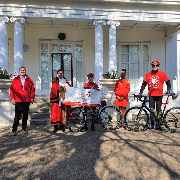 Fundraisers Matthew and Vernon Hill pose with their bikes and the Mayor of Broadstairs, holding a Demelza banner and wearing Demelza t-shirts.
