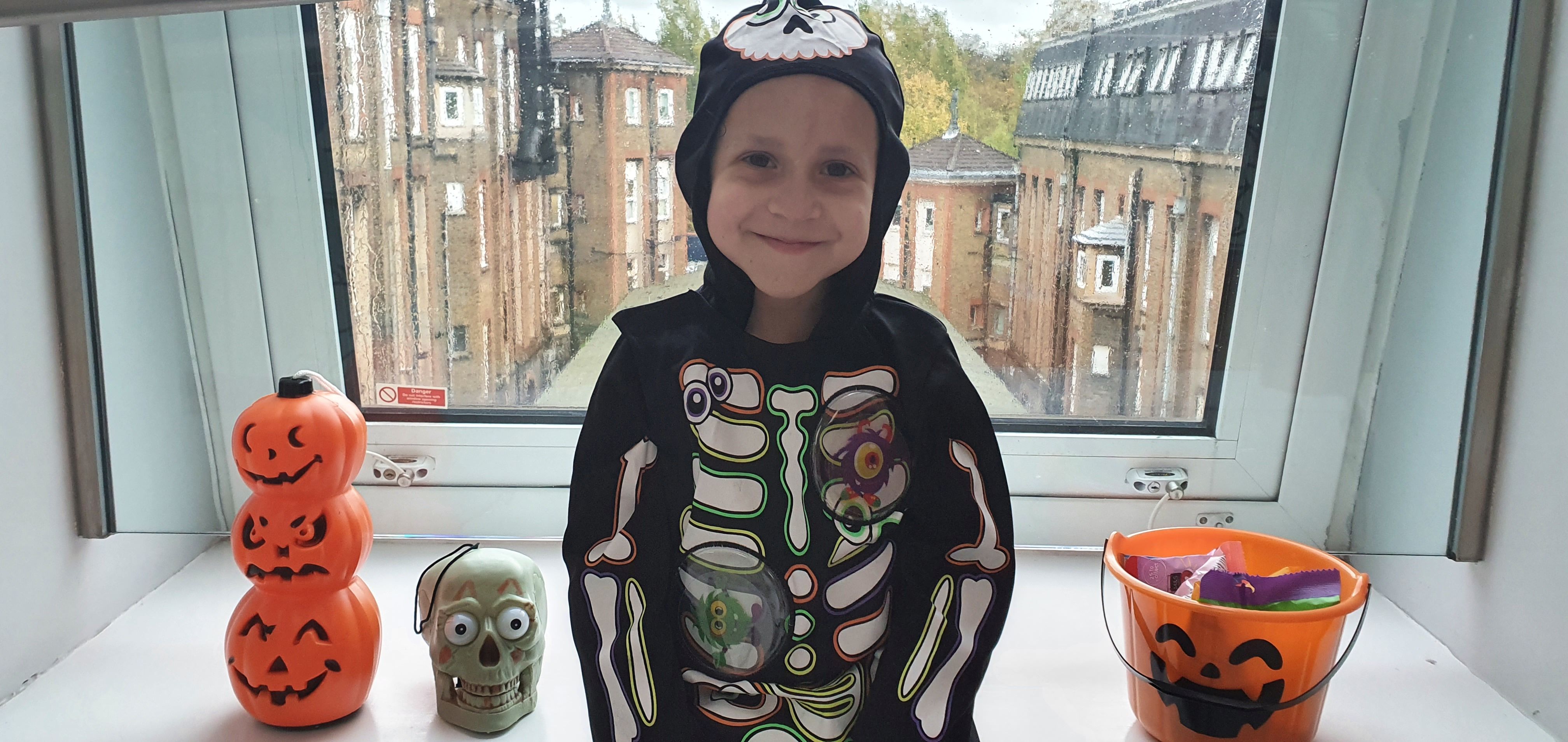 Zak is dressed up in a skeleton costume for Halloween.