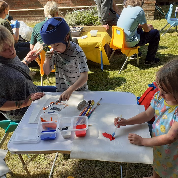 Children enjoying a painting activity in the garden.