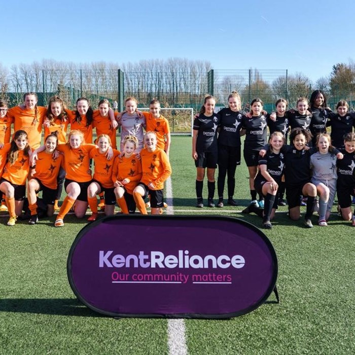 The XL Football Club stand for a team photo, wearing their branded uniforms, with the Demelza logo.